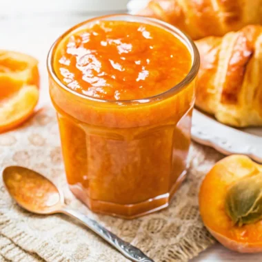 Homemade apricot jam recipe in glass jar with fresh apricots and golden color showing perfect consistency
