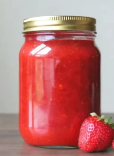 Fresh strawberry freezer jam recipe with Sure-Jell pectin in mason jars, showing step-by-step jam making process with crushed strawberries, sugar, and final preserved product