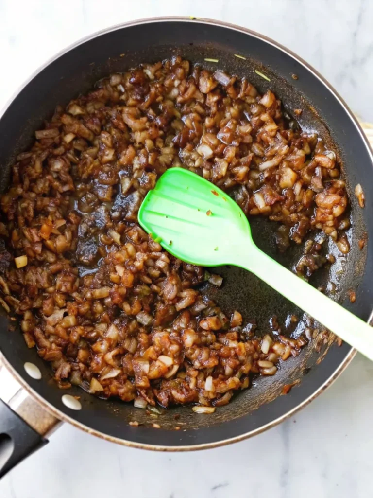 Homemade balsamic onion jam in glass bowl with wooden spoon showing rich caramelized color and jam-like consistency