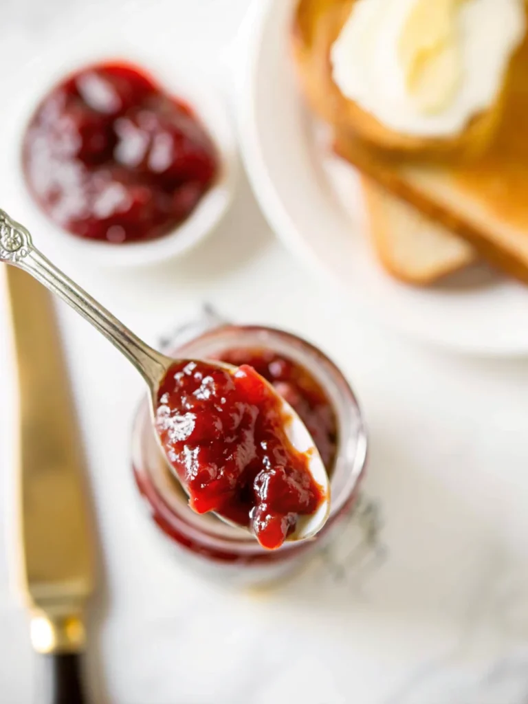 Homemade grape jam recipe in glass jars with fresh grapes and ingredients on wooden table