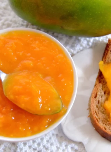 Fresh homemade mango jam in glass jar with golden color and smooth texture, made from ripe mangoes following easy mango jam recipe