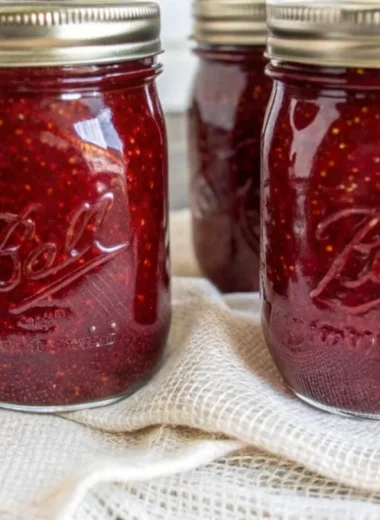 Easy homemade strawberry jam canning recipe showing fresh crushed strawberries, sugar, and pectin ingredients with mason jars and canning supplies for beginners