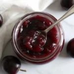 Homemade muscadine jam recipe in glass jars with fresh muscadine grapes, showcasing the rich purple color and thick texture of this antioxidant-rich Southern preserve