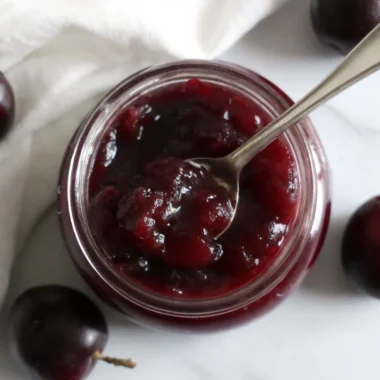 Homemade muscadine jam recipe in glass jars with fresh muscadine grapes, showcasing the rich purple color and thick texture of this antioxidant-rich Southern preserve
